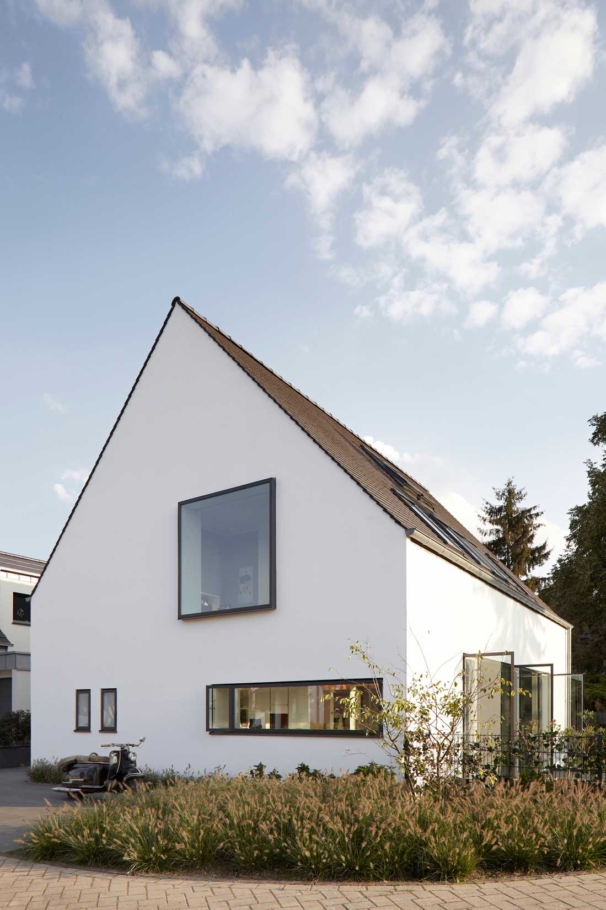 Architekturfotografie Lioba Schneider: Weisses Einfamilienhaus in Troisdorf mit eindeutiger Kubatur- spitzgiebelig, wie ein Kind ein Haus zeichnen würde.