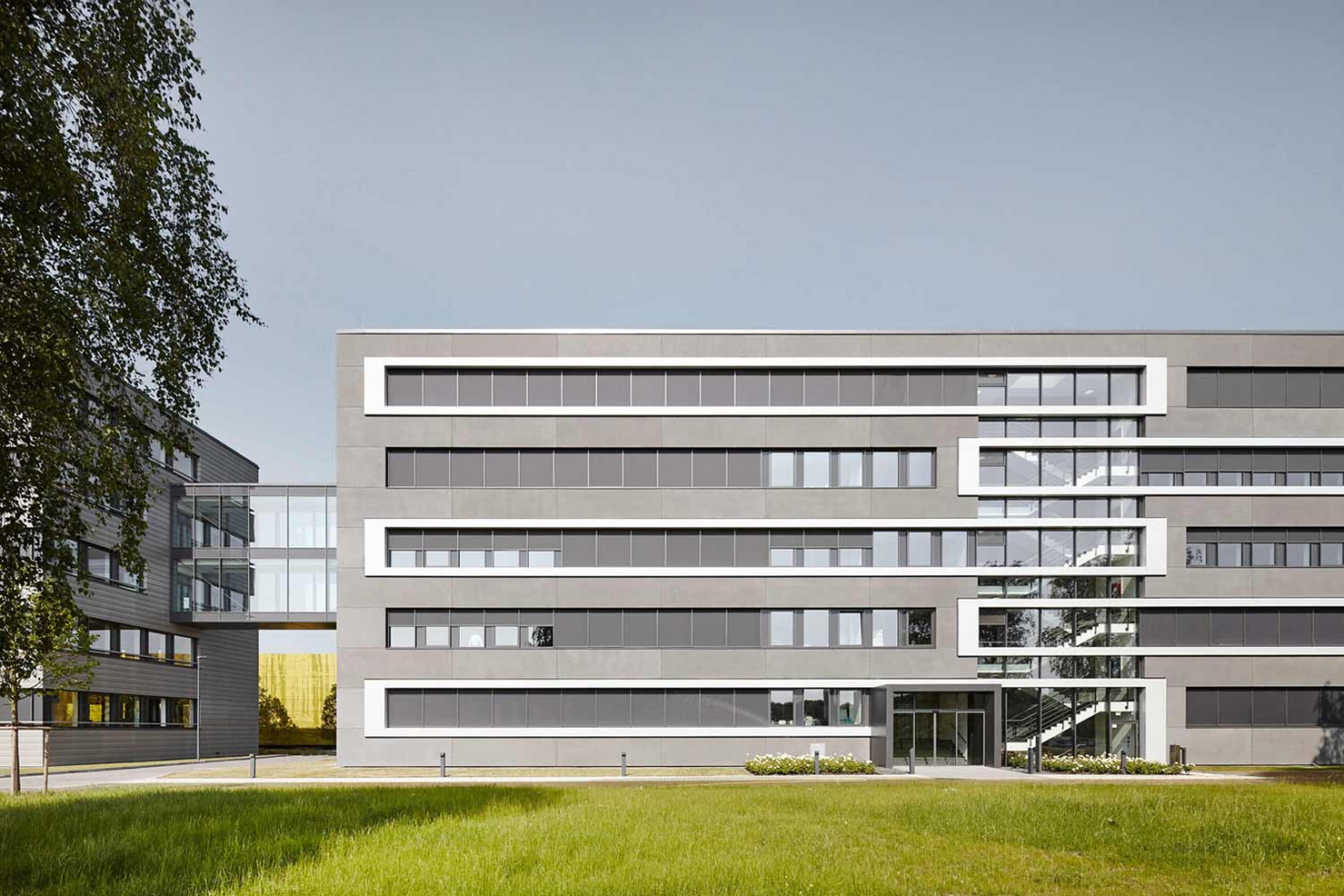 Architekturfotografie NRW Lioba Schneider: Neubau der Firmenzentrale in Essen für ALDI Süd. Mehrstöckige kubische Baukörper werden durch durchgehende Fensterbänder gerastert.