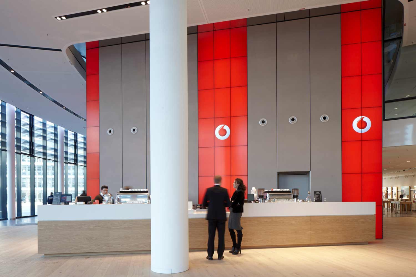 Architekturfotografie Lioba Schneider: Neubau des Vodafone-Campus in Düsseldorf. Eingangsbereich mit Kaffeetresen und Vodafone-Logo.
