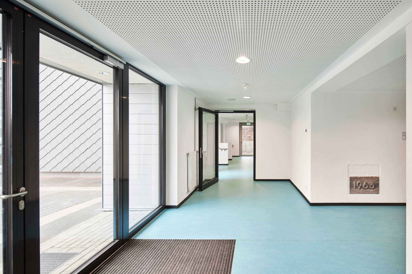 Architekturfotografie: Modern gelöste Sanierung und Erweiterung einer Förderschule in Alfter bei Bonn. Der Flur in hellblau verbindet die einzelnen Bereiche.
