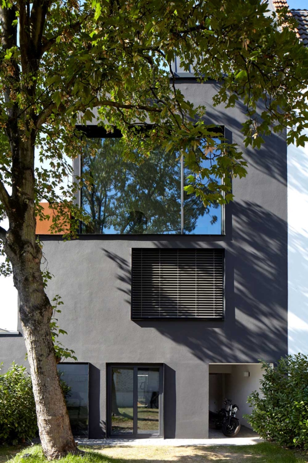 Architekturfotografie in Köln: Anthrazitfarbenes Einfamilienhaus in Köln mit grossen Fenstern mit Baum davor