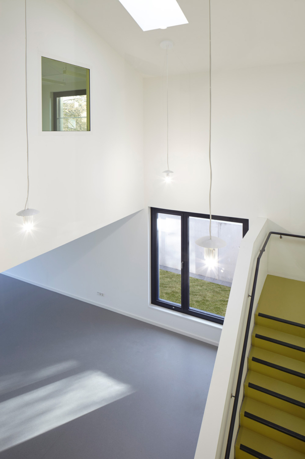Architekturfotografie Lioba Schneider: Neubau des Mädchentreffs in Leverkusen in Holzbauweise. Innen bieten grosse Fenster den Blick in den grosszügigen Luftraum.