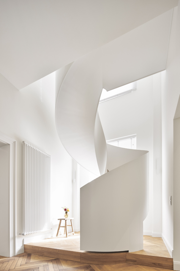 Architekturfotografie: Elegante Wendeltreppe in weiss in einem modernen umgebauten Altbau. Das luftige und helle Interieur zeigt die behutsame Umbauarbeit des denkmalgeschützten Altbaus.
