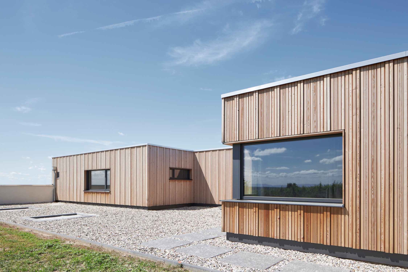 Architekturfotografie Lioba Schneider: engels Architekten haben in den Weinbergen der Pfalz einen weitläufigen Bungalow aus Holz gebaut, mit überkragendem Dach und großen Fensterfronten.