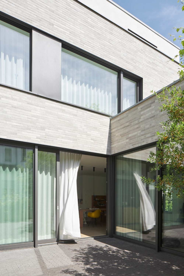 Lioba Schneider Architekturfotografie: Hochwertiger Neubau eines Einfamilienhauses in Köln. Grosse Fenster sind in einer hellen Klinkerfassade eingelassen und lassen viel Licht ins Haus.
