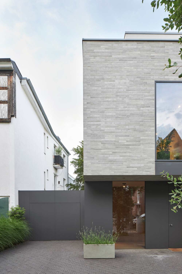 Lioba Schneider Architekturfotografie: Hochwertiger Neubau eines Einfamilienhauses in Köln. Grosse Fenster sind in einer hellen Klinkerfassade eingelassen und lassen viel Licht ins Haus.