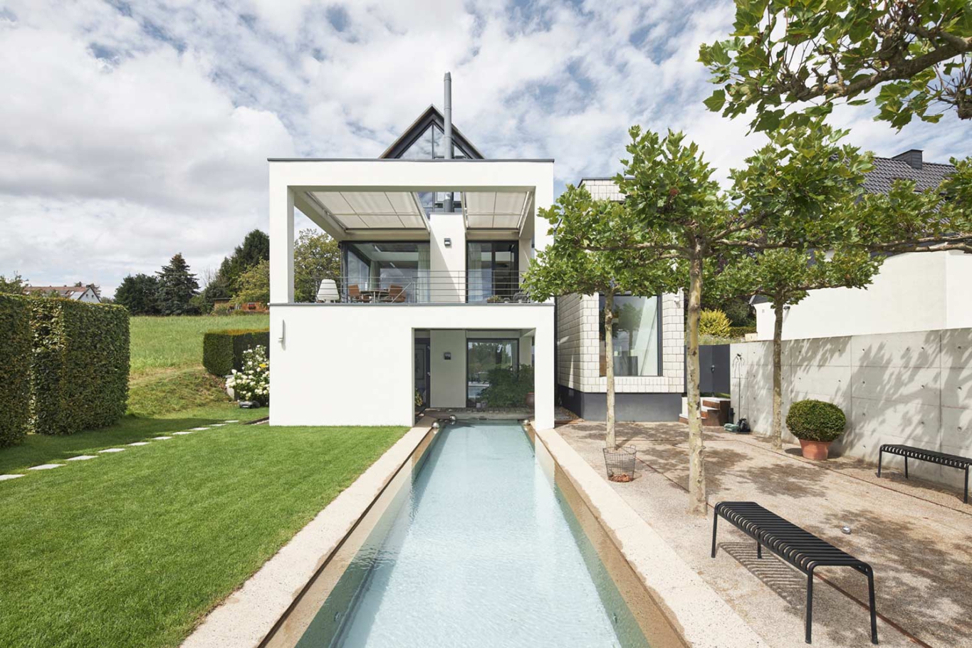 Lioba Schneider Architekturfotografie: grosszügige Gartengestaltung eines Einfamilienhauses mit Pool und Platanen.
