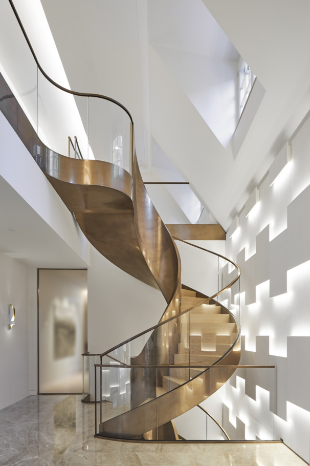 Interiorfotografie: In einer Villa in Köln wurde von der Fa. Metallart eine repräsentative Wendeltreppe über drei Etagen aus Metall (Kupfer) und Glasgeländern gebaut.