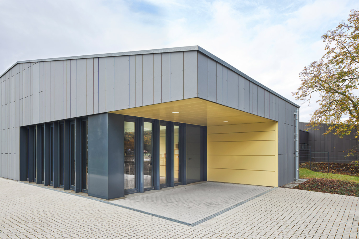 Lioba Schneider Architekturfotografie: Neubau eines Vereinsheims für einen Fussballclub in Monheim. Die Hülle ist aus anthrazitfarbenen Metallpanelen gestaltet.