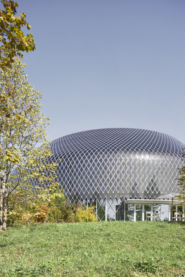 Lioba Schneider Architekturfotografie: Der Novartis-Pavillon in Basel. Die Aussenhaut des kreisrunden Gebäudes besteht aus zahlreichen Photovoltaikzellen und LED- Elementen und, die abends in bunten Farben leuchten.