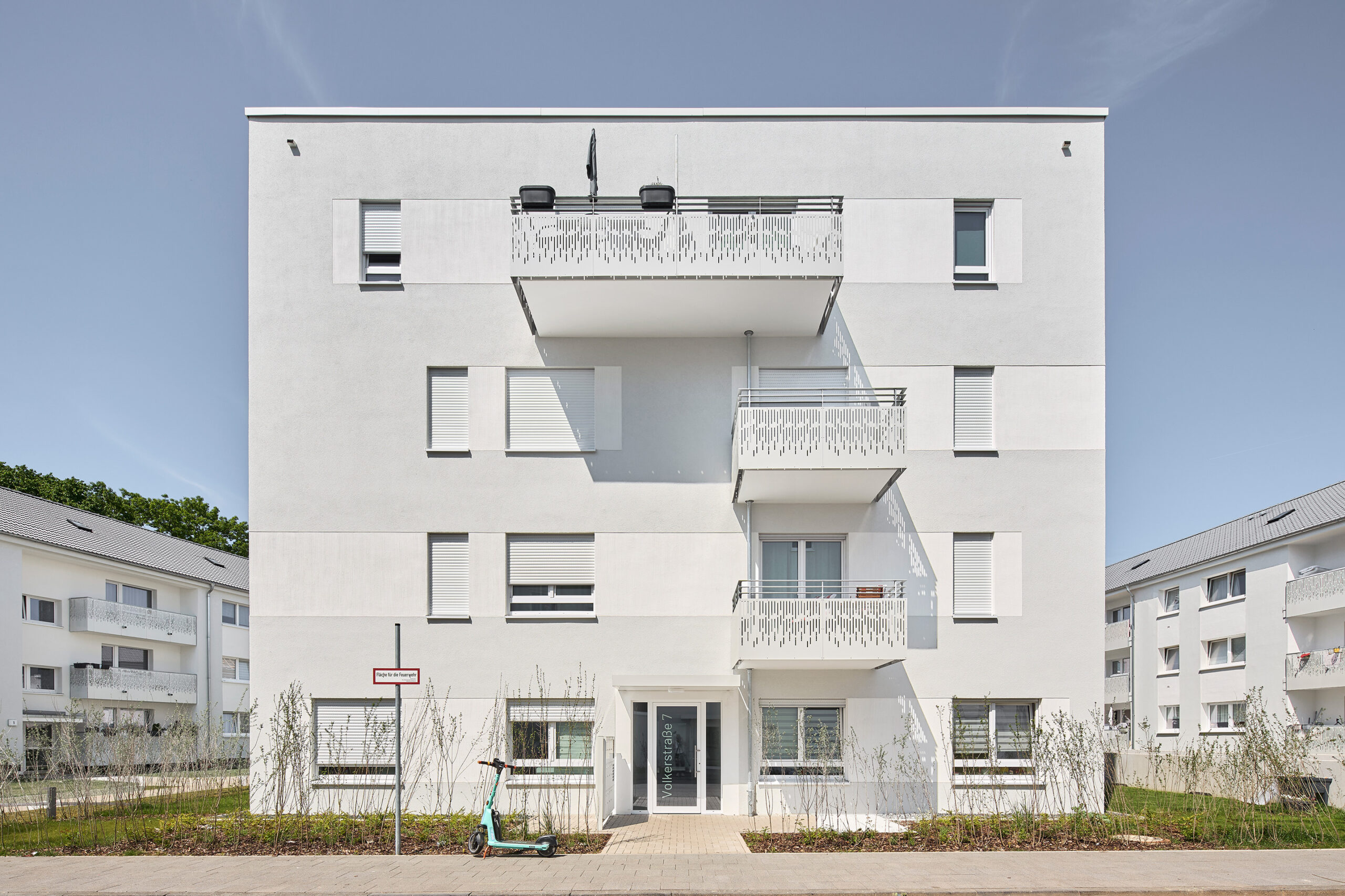 Porzer Würfel Bonn: Nachverdichtung durch Holzbau und sozialen Wohnungsbau – moderne, weiß verputzte Architektur mit Spielplatz und Grünflächen