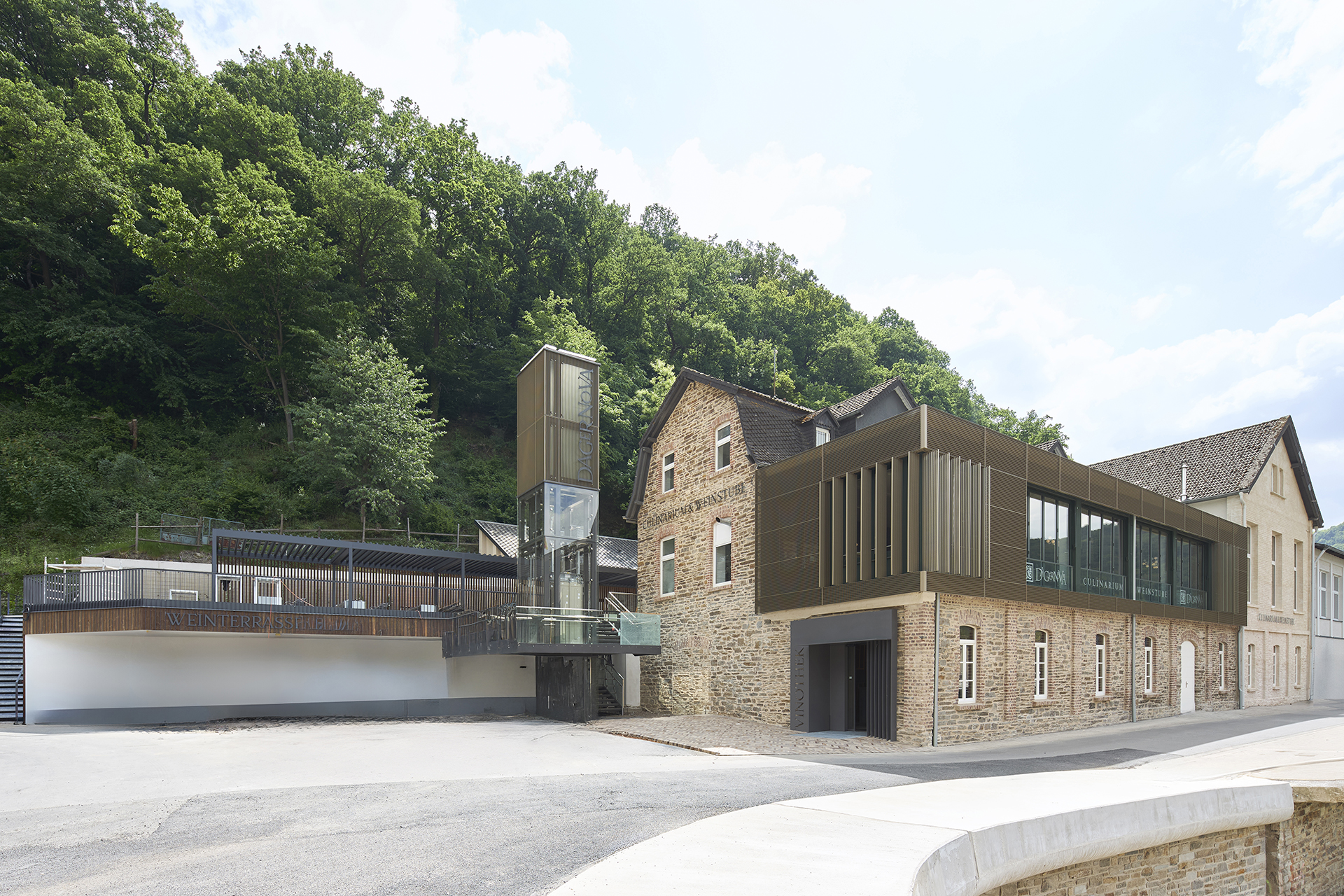 Architekturfotografie des Wiederaufbau des Weinguts der Dagernova.im Ahrtal. Ein Auf- und Anbau aus braunem Metall verbindet sich mit der alten Architektur aus Ziegelgemäuern.
