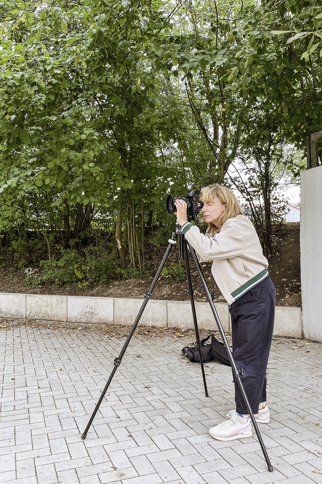 Portrait von Architekturfotografin mit Stativ und Kamera